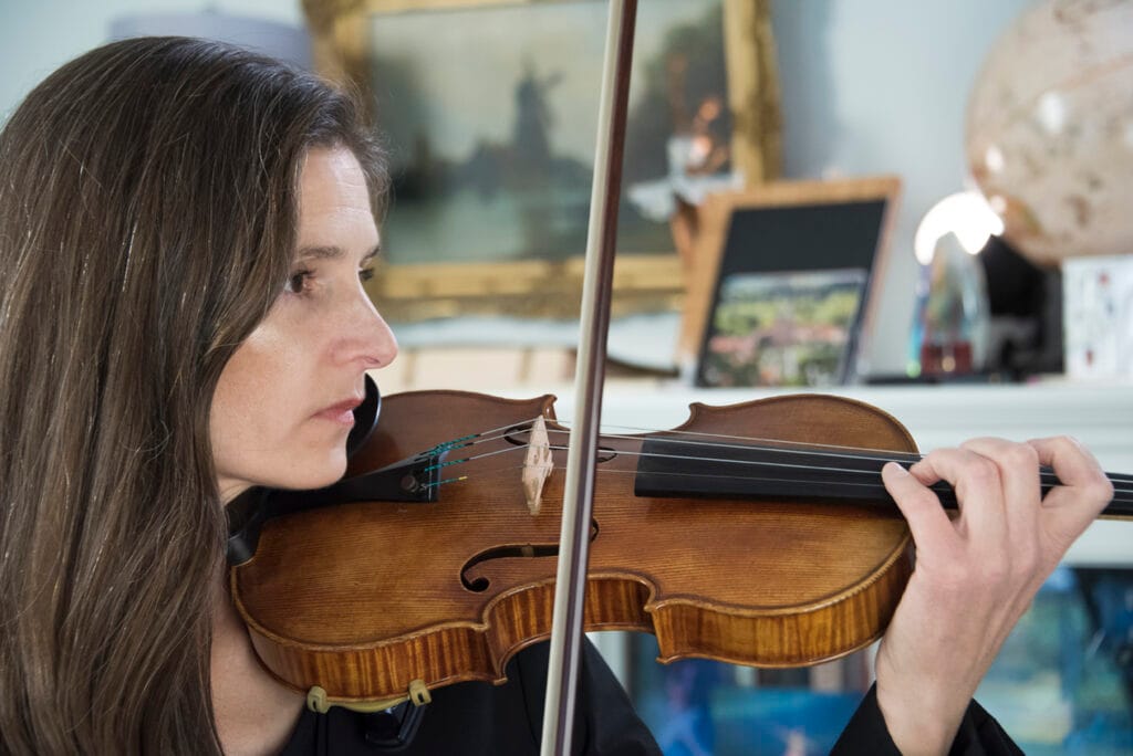 A violin teacher demonstrates bowing technique