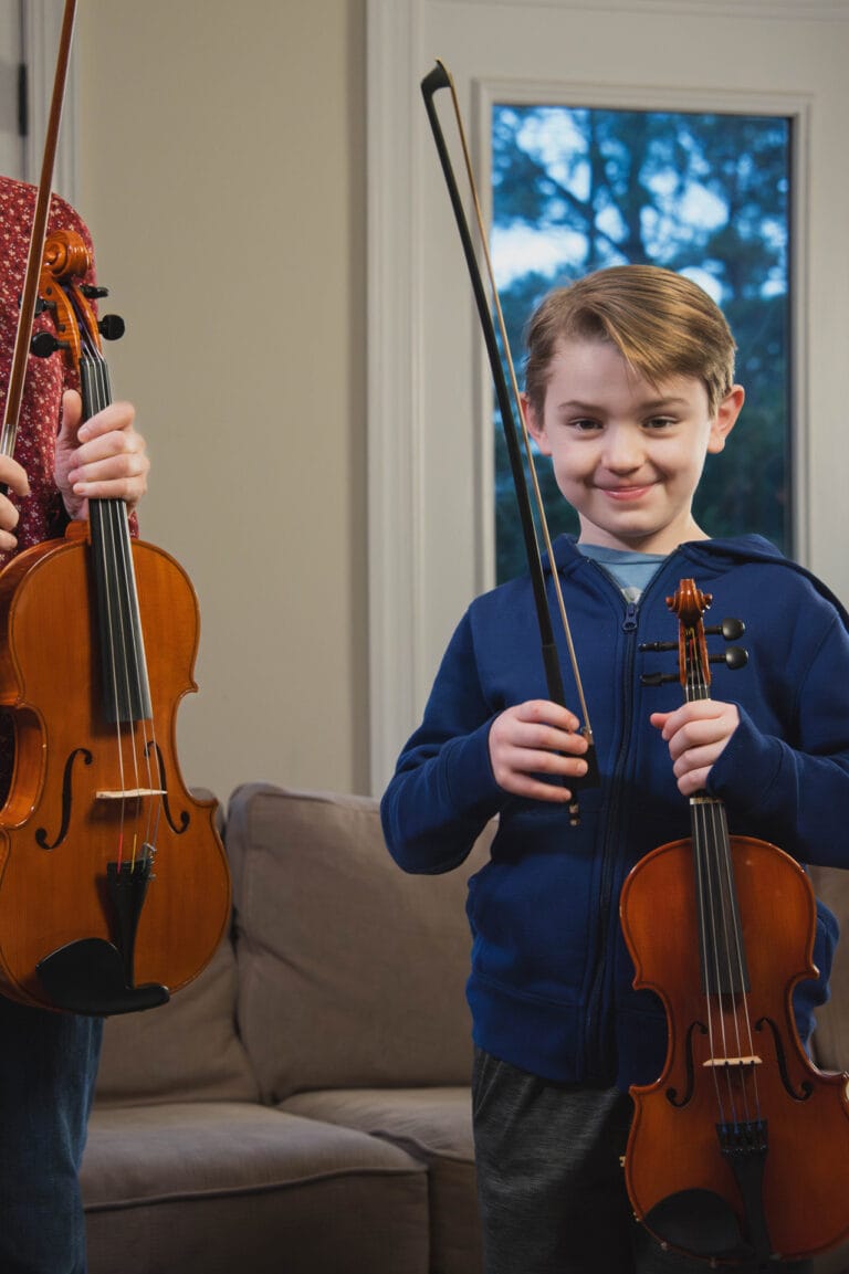 Happy violin student smiling after a successful lesson with instructor